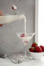 Cream being poured over strawberries in martini glass Royalty Free Stock Photo