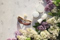 Cream for body care and deodorant on a sunny table with branches of lilac, preparing for summer rest in the sun, copy space, top v