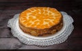 Cream cake with tangerines on mahogany wooden background