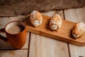 Cream cakes on a wooden plate with a cup of coffee with milk. The concept of natural and delicious food. Royalty Free Stock Photo