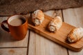 Cream cakes on a wooden plate with a cup of coffee with milk. The concept of natural and delicious food. Royalty Free Stock Photo