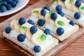 Cream cheese sandwiches idea. Vegetarian crusty bread sandwiches with cheese cream, bananas and berries on wooden board Royalty Free Stock Photo