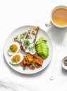 Cream cheese toast, avocado, boiled egg, baked sweet potatoes - delicious healthy breakfast or snack on a light background Royalty Free Stock Photo
