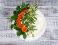 Cream cheese vanilla wedding cake with orange roses Royalty Free Stock Photo