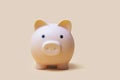 Cream color piggy bank on camel color background