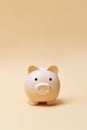 Cream color piggy bank on camel color background