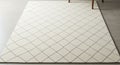 Cream-colored area rug with a subtle grid pattern. The design features diamond Royalty Free Stock Photo