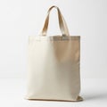 Cream-colored canvas tote bag with short handles, set against a plain white Royalty Free Stock Photo