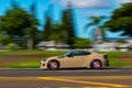 Cream-colored car in motion with a blurry background in Oahu, Hawaii.