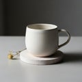 Cream colored ceramic cup with a rounded shape sits on a light wooden Royalty Free Stock Photo