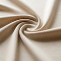 A cream-colored cotton fabric is artistically twisted into a spiral pattern. The fabric Royalty Free Stock Photo