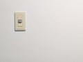 cream-colored light switch mounted on a plain white wall Royalty Free Stock Photo