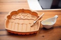 Cream-colored silicone baking dish with a wooden brush