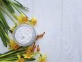 cream cosmetic narcissus capsules on white wooden handmade