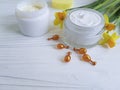 Cream cosmetic narcissus cottage protection capsules on white wooden handmade