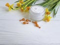 Cream cosmetic narcissus mask glass cottage protection capsules on white wooden handmade