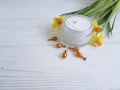 cream cosmetic narcissus protection capsules on white wooden handmade