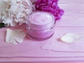 Cream cosmetic natural product treatment peony flower blossom on a pink wooden Royalty Free Stock Photo