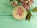 Cream cosmetic pink flowers on mint wood product scrub, handmade