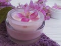 Cream cosmetic pink flowers wellness product handmade on blue wooden Royalty Free Stock Photo