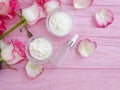 Cream cosmetic rose flower decoration on wooden background