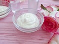 Cream cosmetic rose flower wellness decoration on wooden background