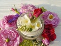 Cream cosmetic rose, jasmine plant on a white wooden background