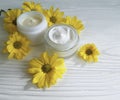 Cream cosmetic yellow daisy flowers handmade container beautiful relaxation on a white wooden background Royalty Free Stock Photo