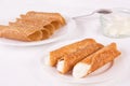 Cream filled brandy snaps and unfilled snaps and a pot with cream Royalty Free Stock Photo