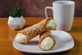 Cream filled cannoli with a cup of coffee