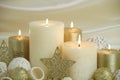 Cream and gold Christmas candles on cream colored background with gold stars Royalty Free Stock Photo
