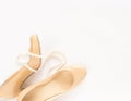 Cream heeled women`s shoes and pearls necklace on white background. Royalty Free Stock Photo