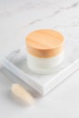 Cream jar on marble tray. Cosmetic skincare product blank frosted glass package. White unbranded lotion, balm, cream