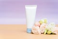 Cream and lotion in white tubes on a beige background with flowers of roses. Cosmetic products for skin care from natural Royalty Free Stock Photo