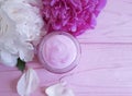 Cream moisturize cosmetic, peony flower product treatment rustic on a pink wooden background Royalty Free Stock Photo