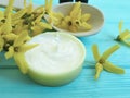 Cream product cosmetic skin extract natural care yellow ointment flowers on a wooden background