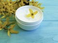 Cream product cosmetic skin yellow ointment flowers on a wooden background