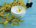 Cream product cosmetic yellow ointment flowers on a wooden background