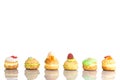 Cream puff cakes or profiterole filled with whipped cream with fruit and decoration in line