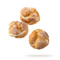 Cream puffs, pastry from choux covered sugar powder closeup falling flying isolated on white Royalty Free Stock Photo