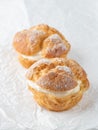 Cream puffs, pastry from choux covered sugar powder on white paper Royalty Free Stock Photo