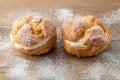 Cream puffs, pastry from choux covered sugar powder on wooden table Royalty Free Stock Photo