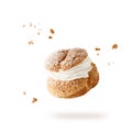 Cream puffs, pastry from choux filled vanila cream covered sugar powder and crumbs closeup falling flying isolated on white Royalty Free Stock Photo