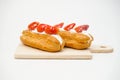 Cream puffs with strawberries slices on cake isolated on white background Royalty Free Stock Photo