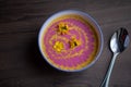 Cream pumpkin and beet soup with fresh yellow flowers
