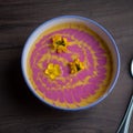Cream pumpkin and beet soup with fresh yellow flowers
