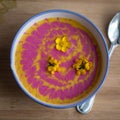 Cream pumpkin and beet soup with fresh yellow flowers