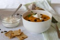 Cream of pumpkin soup with whipped cream and crackers isolated on white blanket with salmon rolls on a wooden skewer Royalty Free Stock Photo