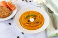 Cream of pumpkin soup with whipped cream and crackers isolated on white blanket with salmon rolls on a wooden skewer. Royalty Free Stock Photo