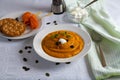 Cream of pumpkin soup with whipped cream and crackers isolated on white blanket with salmon rolls on a wooden skewer. Royalty Free Stock Photo